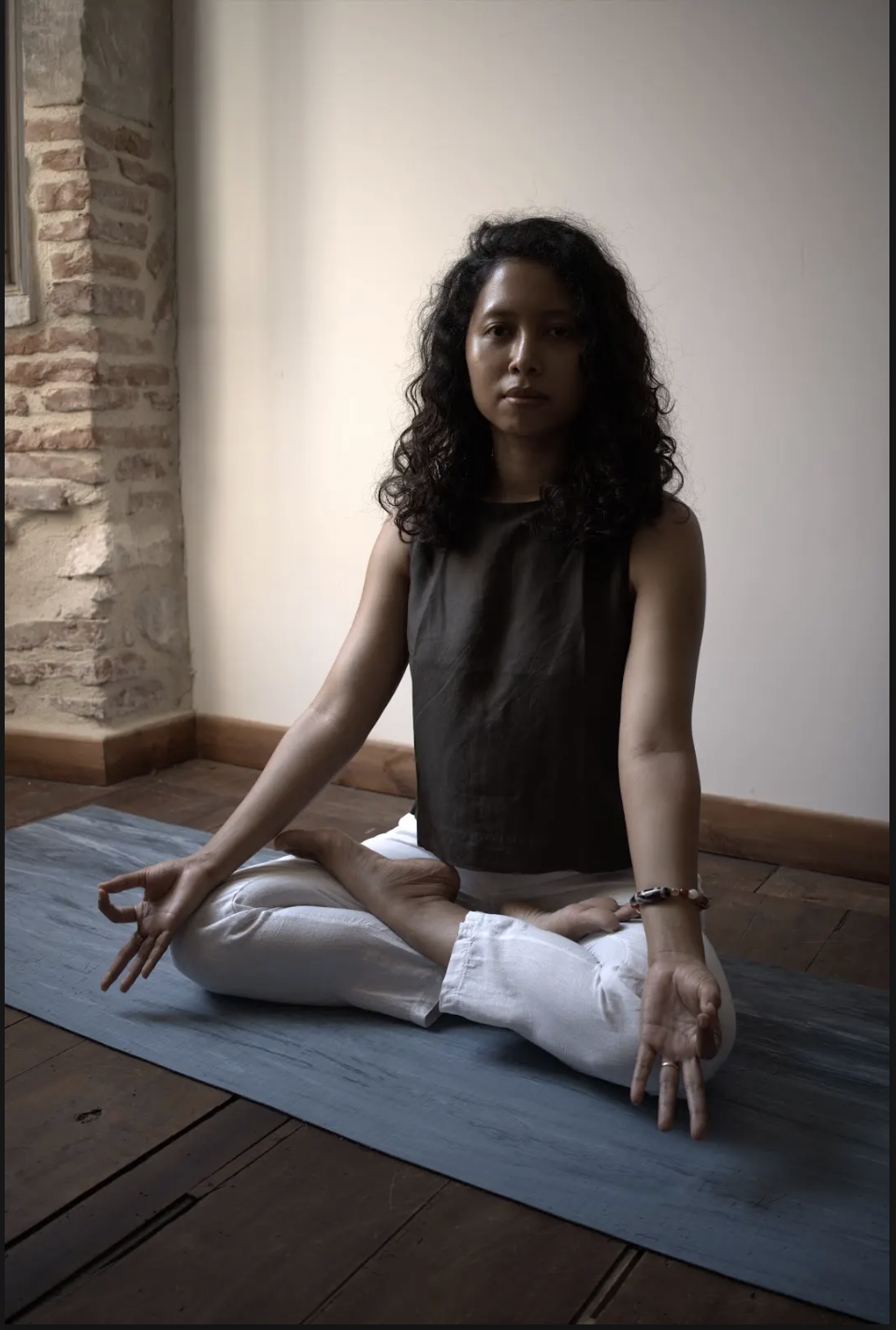 Hsu Zin seated in a cross-legged meditation pose with hands in gyan mudra